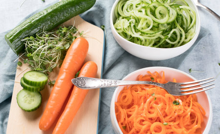 Fresh carrots and green peas on a blue background. Vegan food concept. healthy eating. Top view.の写真素材