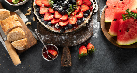 Homemade Strawberry and Blueberry tart with watermelon and jam for dessert on a gray background. Top view. Copy space.の写真素材