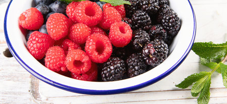 Different fresh berries in a bowl. Antioxidant food concept. Top view.