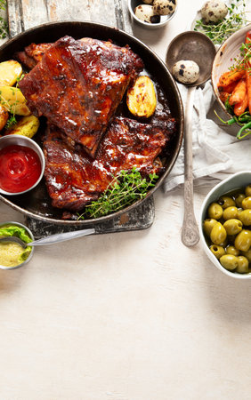 Tasty roasted ribs with baked potatoes vegetables and olives on a white background. Top view.の写真素材