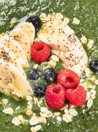Green smoothie bowl with fresh berries for healthy vegetarian diet breakfast. Top view.の写真素材