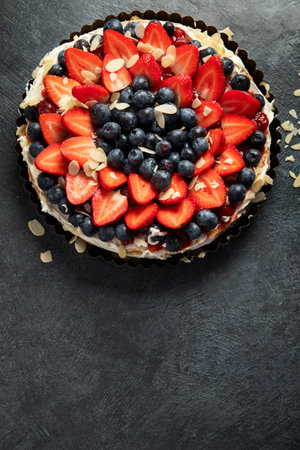 Delicious tart with fresh strawberries and blackberries on a gray background. Top view. Copy spaceの写真素材