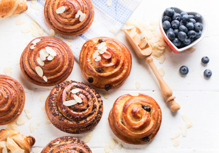 A variety of delicious, fresh pastries, buns and croissants on a white background. Top view.の写真素材