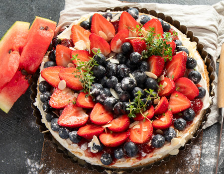 Delicious tart with fresh strawberries and blackberries on a gray background. Top view.の写真素材