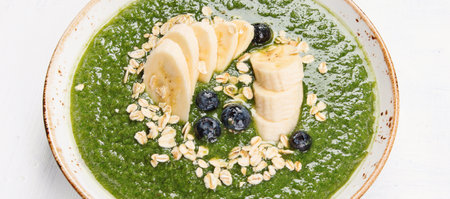 Green smoothie bowl with fresh berries for healthy vegetarian diet breakfast. Top view. Panorama.の写真素材