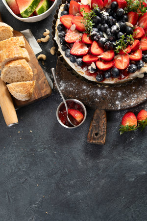 Homemade Strawberry and Blueberry tart with watermelon and jam for dessert on a gray background. Top view. Copy space.の写真素材