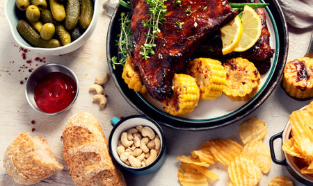 BBQ ribs with vegetables, sauce, roasted corn and watermelon on a white background. Top view. Copy space.の写真素材