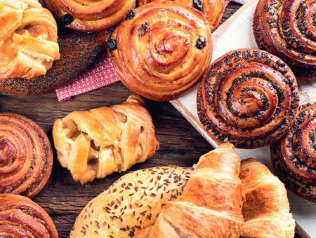 Breads, buns, croissants. Bakery ingredients on a wooden background. Breakfast food concept. Top view. Panorama.の写真素材