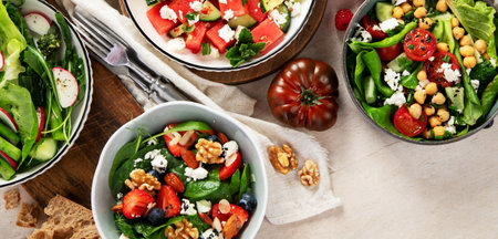 Various summer salads with strawberry, herbs. Healthy salad with arugula, peaches, burrata, blueberries and walnuts on a light background. Fresh healthy dish for healthy eating. Top view.の写真素材