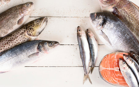 Fresh fish and seafood on a white wooden background. Healthy eating. Top view.の写真素材