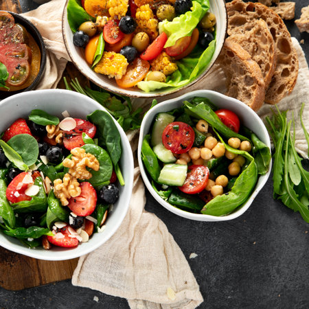 Fresh vegan summer salads with vegetables, fruits and nuts on a dark background. Top view.の写真素材