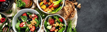 Fresh vegan summer salads with vegetables, fruits and nuts on a dark background. Top view. Panorama with copy space.の写真素材