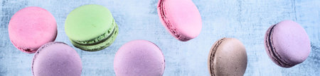 French sweet macaroons flying in motion on a blue background. Panorama.の写真素材