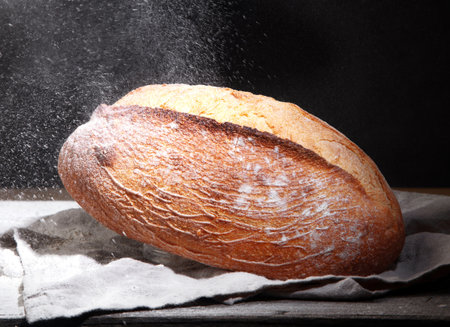 Fresh bread on black background. Traditional bakery concept.