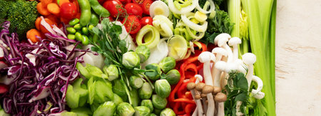 Variety of fresh chopped vegetables: carrots, cucumber, red bell pepper, tomato, salad, onion on a...