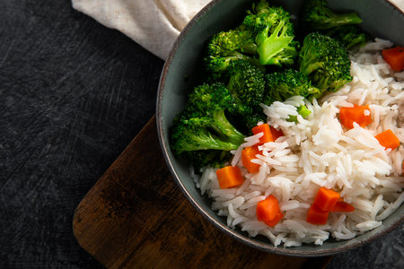Vegan food. Rice with broccoli and green beans in a bowl on a light background. Top view.の写真素材