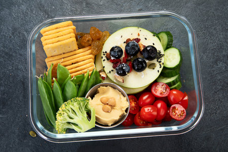 Lunchboxes with various healthy nutritious meals. Concept of healthy snacks in boxes on a dark background. Top view.の写真素材