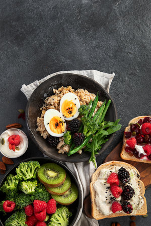 Bowls of vegan porridge with vegetables, sandwiches with fruits. Healthy eating. Top view.の写真素材