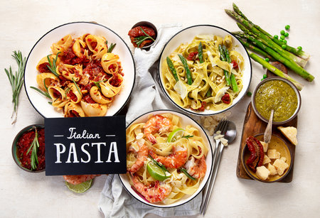 Italian pasta variety. Spaghetti with meat tomato sauce, seafood pasta, vegetarian pasta on a light background. Top view.の写真素材