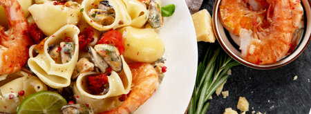 Classic Italian pasta marinara with mussels and shrimps on a dark background. Top view. Panorama, bannerの写真素材