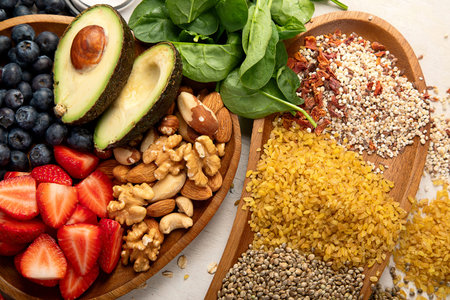 Healthy heart diet concept. Vegetables, olive oil, berries and nuts. Heart-healthy products on a light background. Top view.