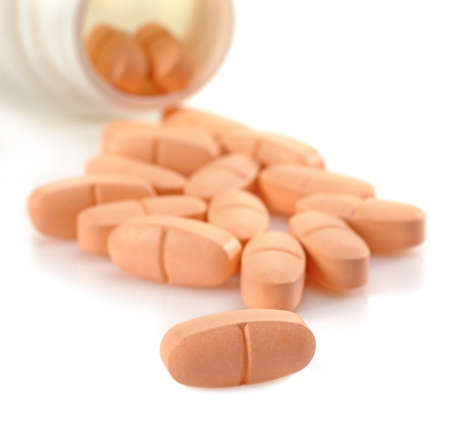 Orange pills pouring out of bottle