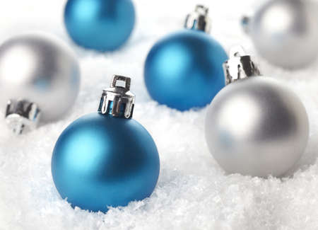 Blue and silver Christmas decorations in snowの写真素材