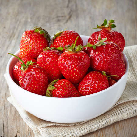 Bowl of fresh strawberries on wooden backgroundの写真素材