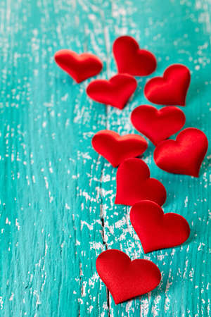 Red hearts on blue wooden backgroundの写真素材