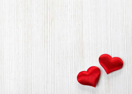Two red hearts on white wooden backgroundの写真素材