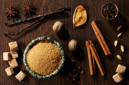 Brown sugar and spices on dark wooden backgroundの写真素材