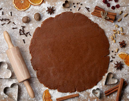 Gingerbread baking dough with spices, cookie cutters and rolling pin, view from aboveの写真素材