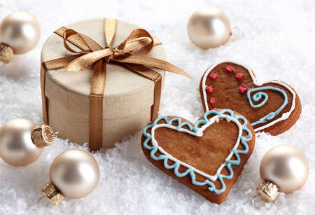 Golden Christmas decorations and gingerbread cookies in snowの写真素材