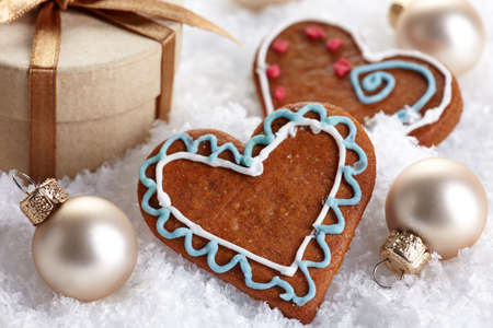 Golden Christmas decorations and gingerbread cookies in snowの写真素材