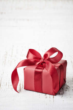 Red gift box on white wooden backgroundの写真素材