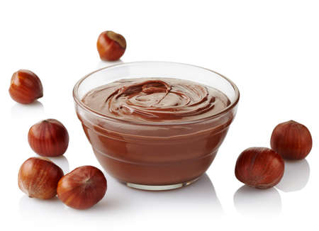 Bowl of chocolate cream and hazelnuts isolated on white の写真素材