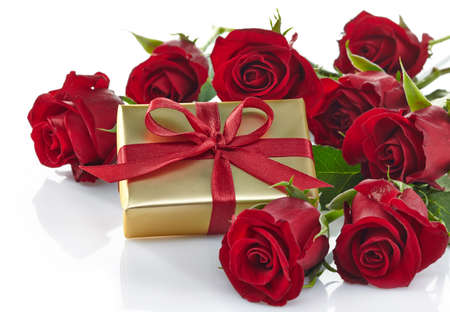 Golden gift box and bouquet of red roses isolated on white backgroundの写真素材