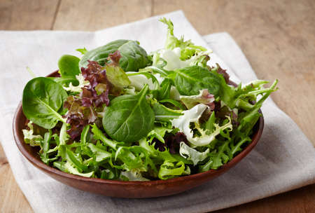 Bowl of fresh mixed salad on wooden backgroundの写真素材