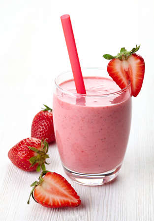 Glass of strawberry smoothie and fresh strawberries