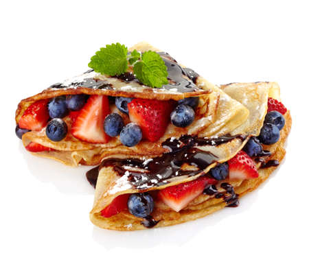 Pancakes with fresh berries and chocolate sauce isolated on white backgroundの写真素材