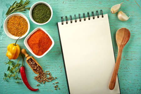 Recipe book and various spices on blue wooden backgroundの写真素材