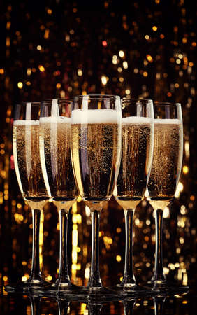 Five flutes of champagne on bokeh backgroundの写真素材