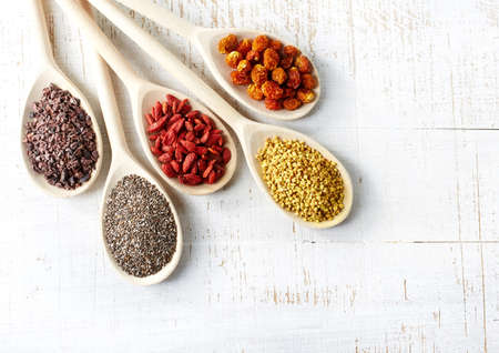 Wooden spoons of various superfoods on white wooden backgroundの写真素材