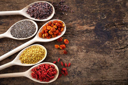 Wooden spoons of various superfoods on old wooden backgroundの写真素材