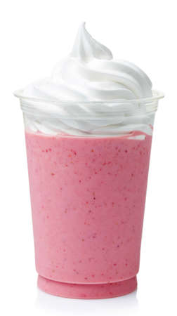 Strawberry milkshake covered with whipped cream in plastic glass isolated on white backgroundの写真素材