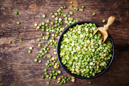 Bowl of green split peas on wooden backgroundの写真素材