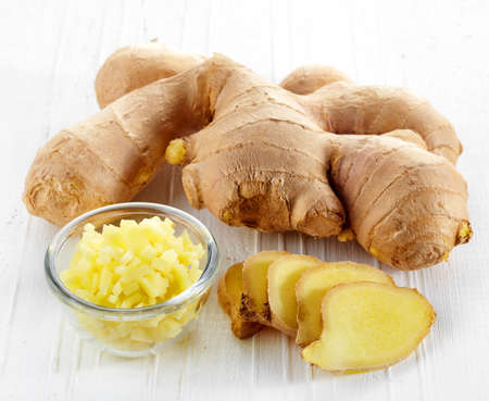 Fresh sliced ginger root on white wooden backgroundの写真素材