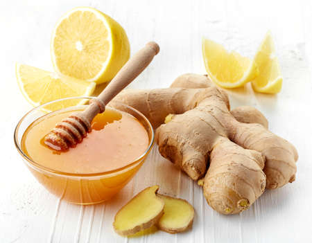Fresh ginger root, honey and lemon on white wooden backgroundの写真素材
