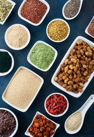 Bowls of various superfoods on old blue background. Top viewの写真素材