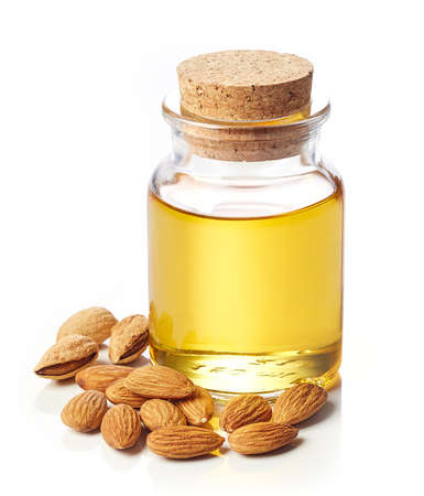 Bottle of almond oil and almonds isolated on white backgroundの写真素材